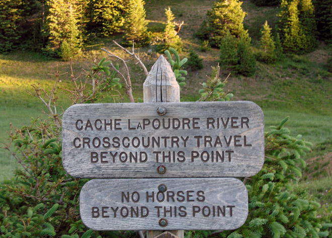 Signs posted at the Cache la Poudre trailhead - with bull elk watching me in the background