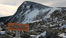 Sign marking the top of Tyndall Glacier with Hallett Peak in the background