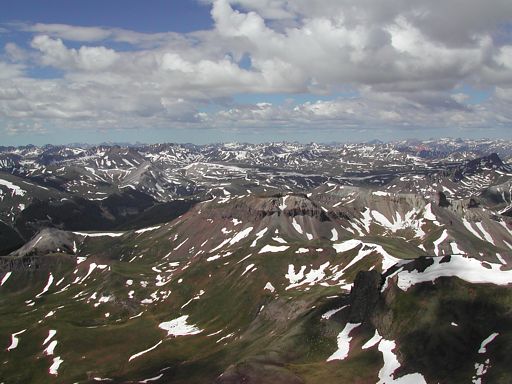 Beautiful endless view of the mountains from Wetterhorn Peak, with scattered snow patterns everywhere.